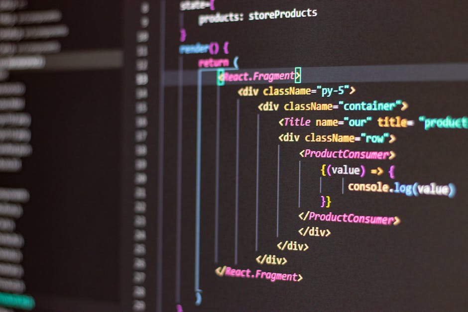 Close-up of a MacBook Pro laptop displaying a dark-themed code editor with HTML and JavaScript code visible on the screen, including elements such as divs, links, images with alt text, and buttons. Th